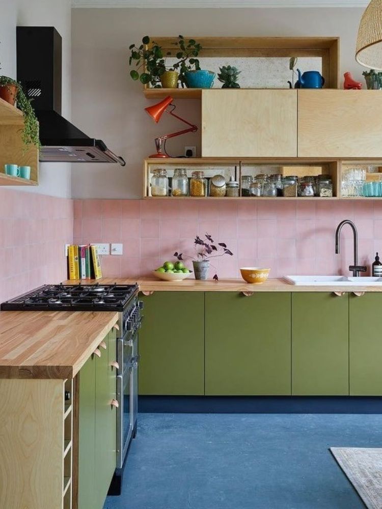 Cozinha colorida com azulejo rosa, armários verdes, piso azul
