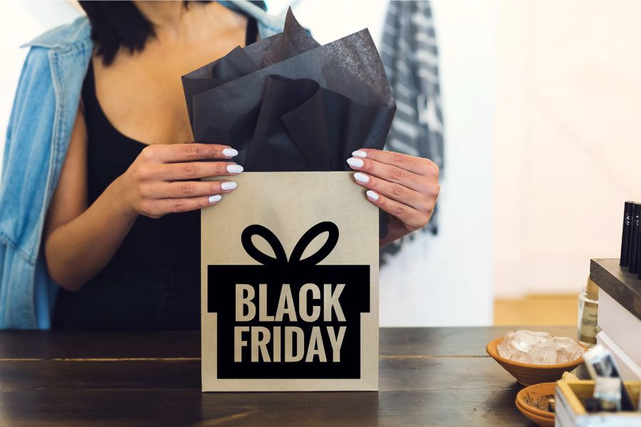 Foto de pessoa enrolando presente na black friday