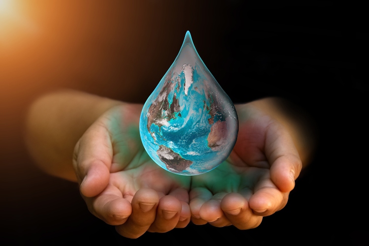 Mãos segurando montagem de mundo em forma de gota