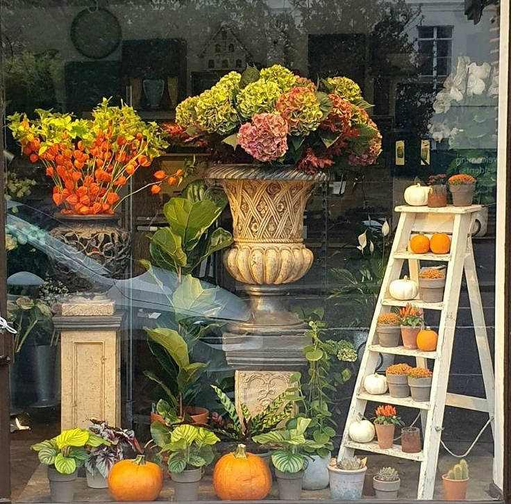 Foto de uma fachada de Halloween com flores, folhas e abóboras