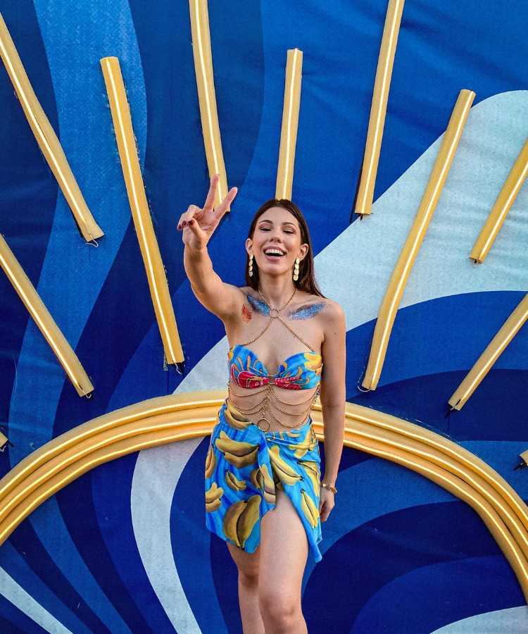 Mulher usando abadá personalizado de Carnaval em forma de top e saia com correntes.