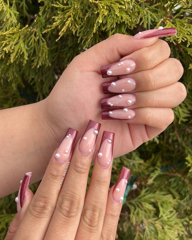 Foto de unhas decoradas com pérolas.