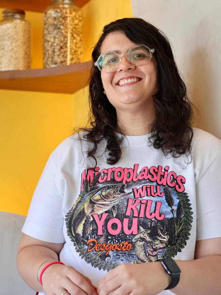 Alice Santiago usando camiseta branca com estampa em fundo amarelo 