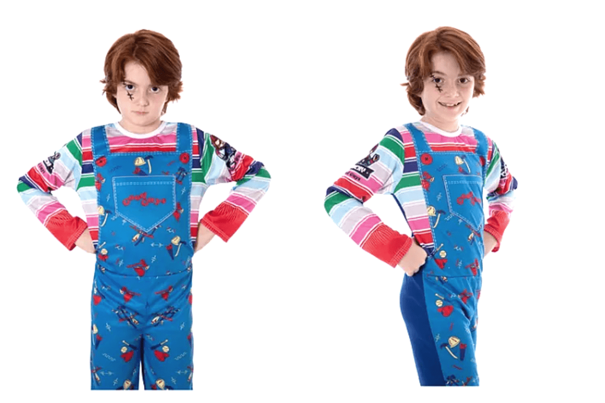 menino fantasiado de chucky, o boneco assassino. A fantasia consiste em uma blusa colorida e, por cima, um macacão azul. O menino também está com uma maquiagem para se parecer mais com o boneco