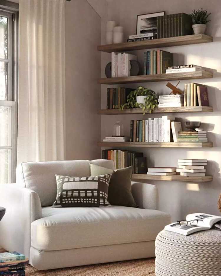 canto de sala com poltrona branca e prateleiras de madeira com livros