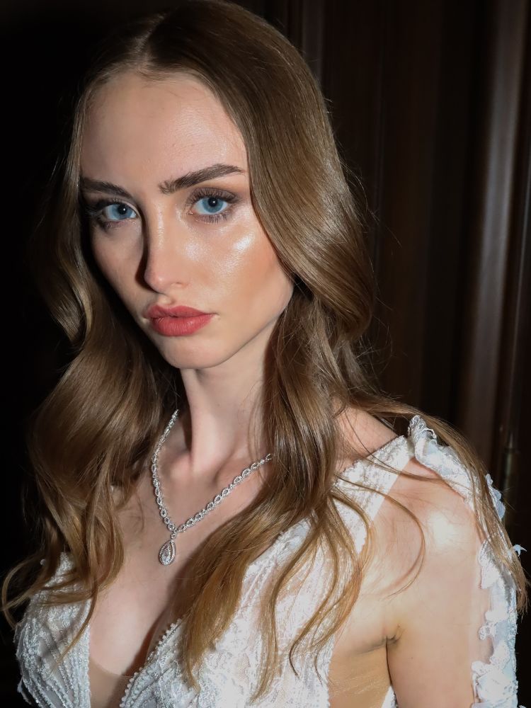 Mulher de pele clara usando vestido de noiva, cabelo solto e maquiagem natural com pele iluminada