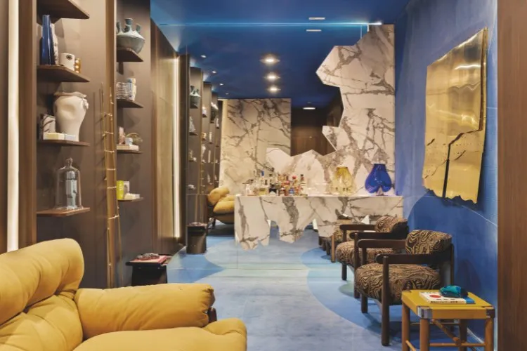 Hall azul com paredes de mármore, espelho grande, cores caramelo e mais 
