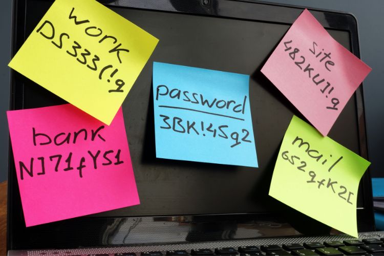 Senhas em post-it colados em tela de notebook