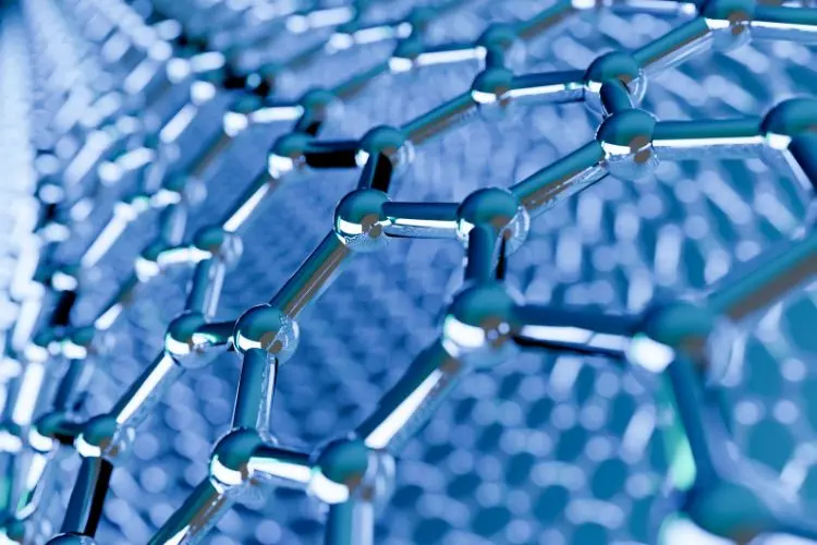 Esta imagem mostra uma estrutura 3D de grafeno, em tons de azul e prata. A malha hexagonal de átomos, interligados por ligações químicas, é o foco, com brilhos metálicos nas esferas.