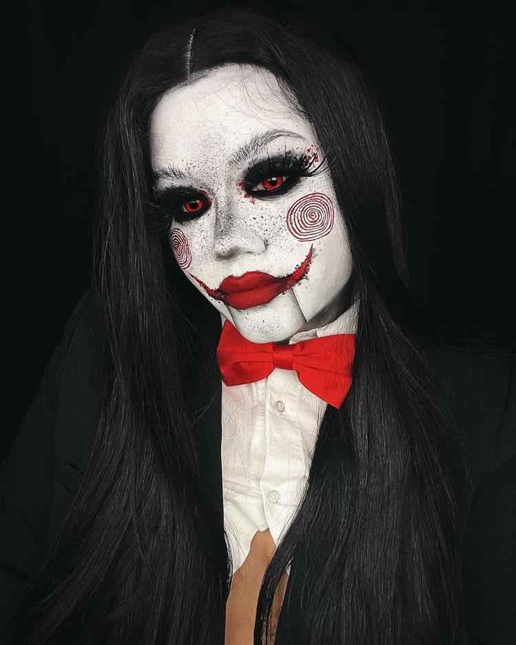 mulher com fantasia de halloween assustadora, rosto branco e detalhes em vermelho dos jogos mortais