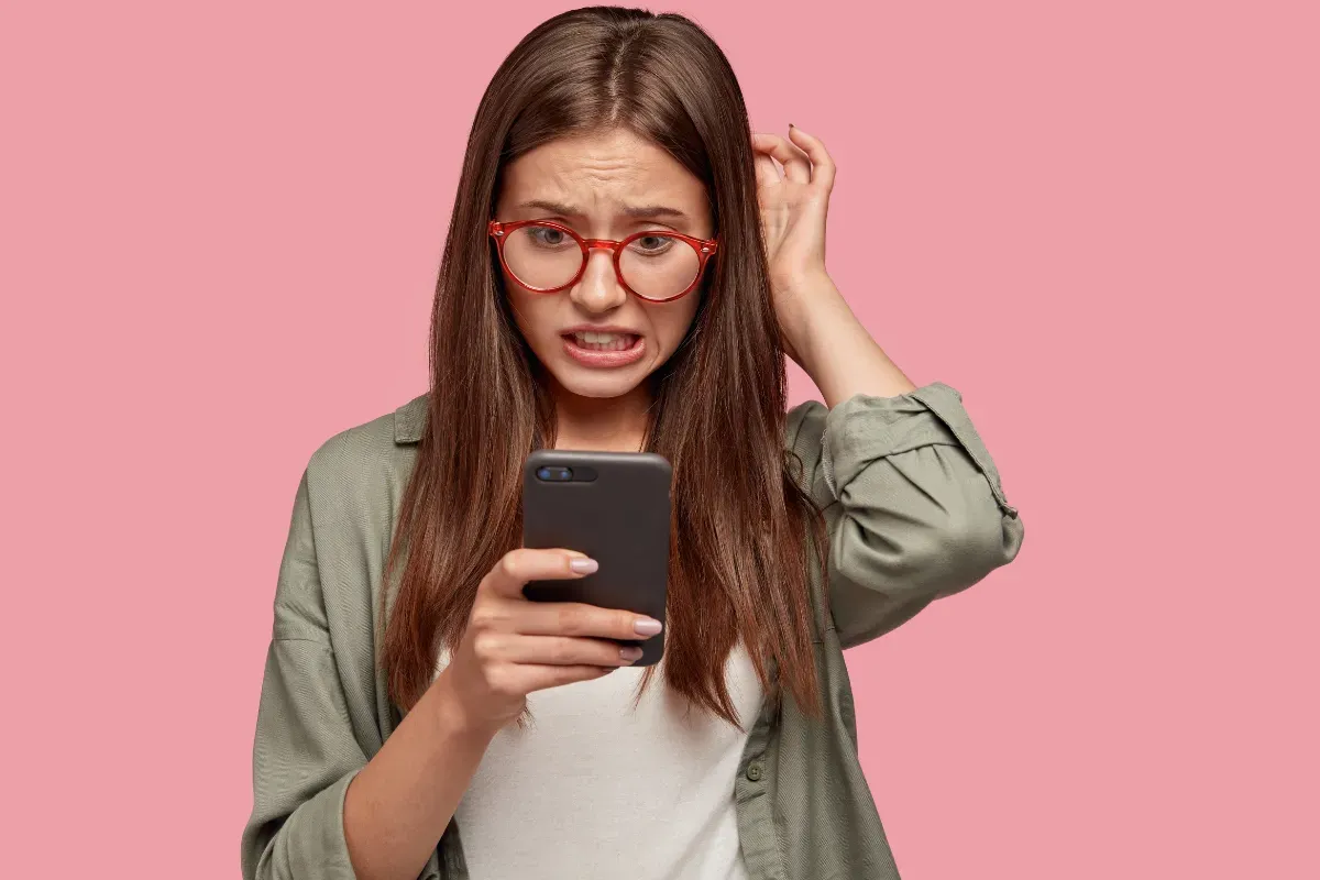 Pessoa segurando smartphone e cartão de crédito para escolher uma forma de pagamento