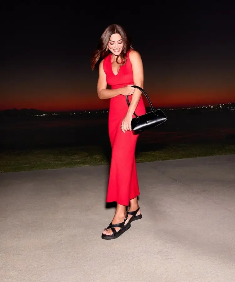Foto de Juliana Paes no Caminho Niemeyer, em Niteroi, usando vestido mídi vermelho, bolsa baguete e papete preta
