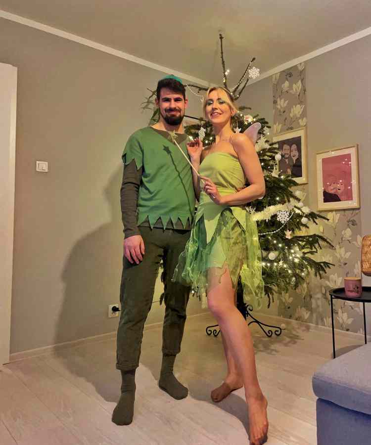 Fantasia de casal para o Halloween: Sininho e Peter Pan. Ele usa roupa marrom e verde e ela usa vestido verde com asas 
