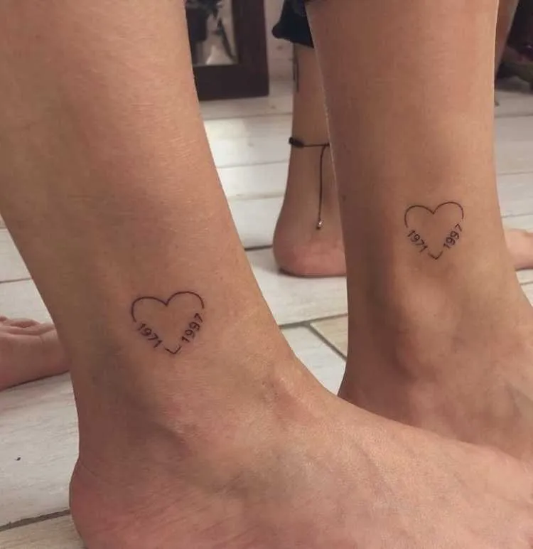 tatuagem mãe e filho na canela, coração com o ano de cada um nas bordas