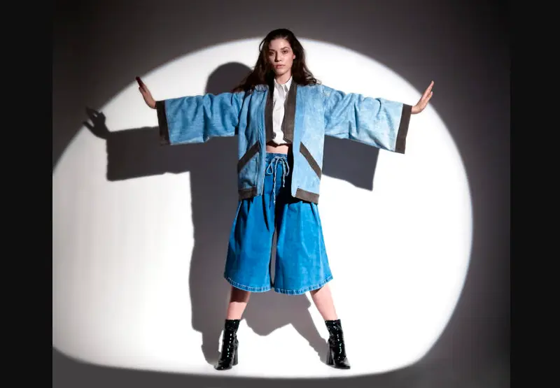 Modelo usa kimono e calça pantalona midi em jeans leve e botas pretas