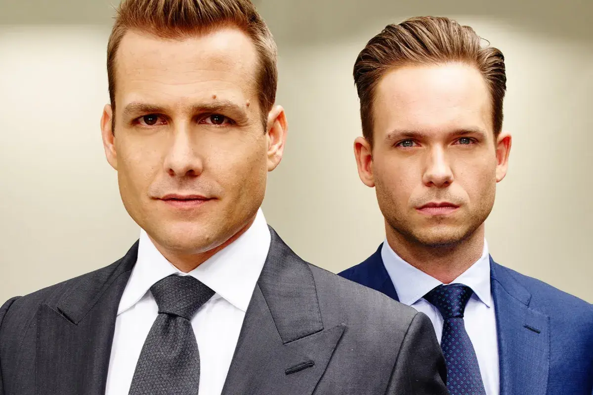 Dois personagens da série Suits usando ternos formais em retrato com fundo neutro