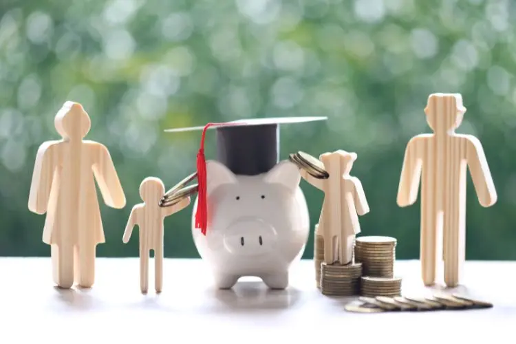 Um cofrinho de porco com chapéu de formatura está cercado por figuras de madeira representando uma família. Ao lado, moedas empilhadas simbolizam economia e investimento para educação. O fundo verde desfocado sugere crescimento e estabilidade financeira futura - - investir com pouco dinheiro