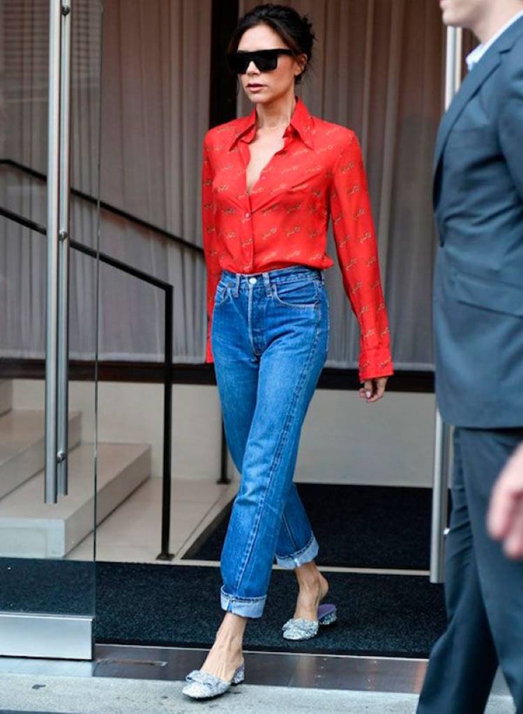 Vitória Beckham usando camisa vermelha, calça jeans cintura média e mule prateado