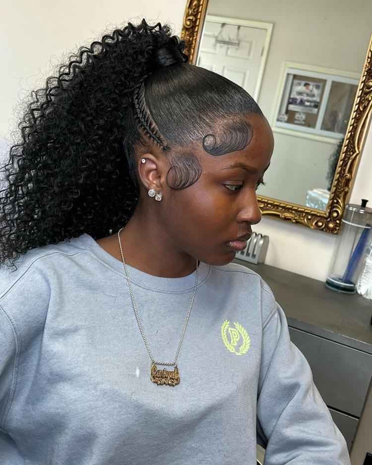 Mulher de pele negra com cabelo volumoso em rabo alto e baby hair