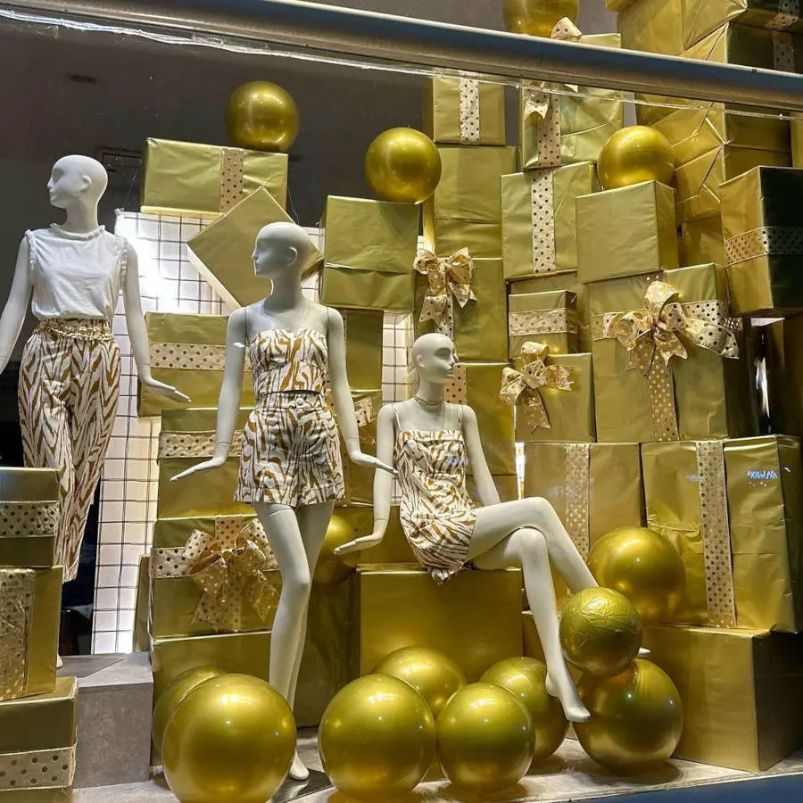 Vitrine com presentes e bolas douradas.