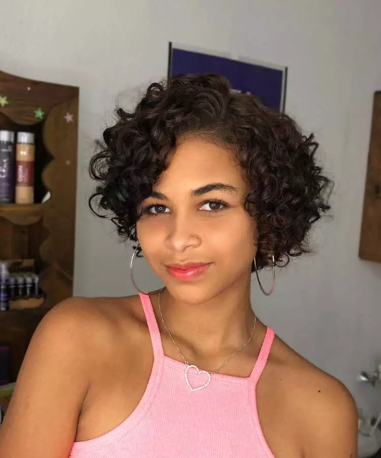 Corte assimétrico mulher com cabelo castanho ondulado