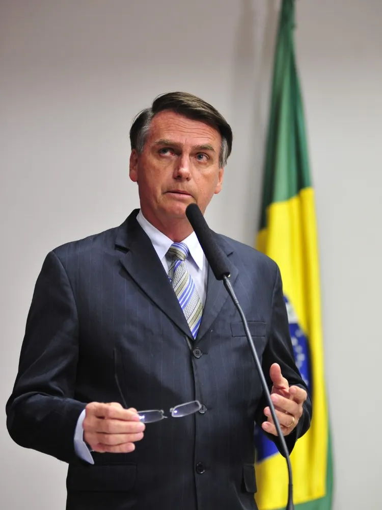 Bolsonaro em palanque com bandeira do Brasil ao fundo