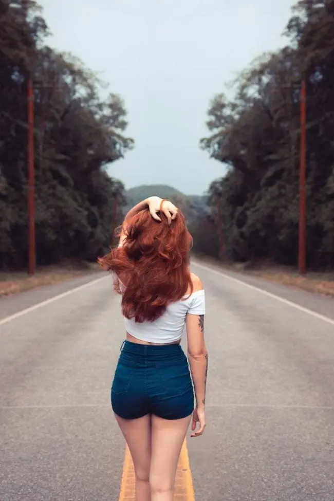 Frase para foto pensativa mulher ruiva na estrada com short jeans e camisa branca Frase para foto pensativa mulher ruiva na estrada