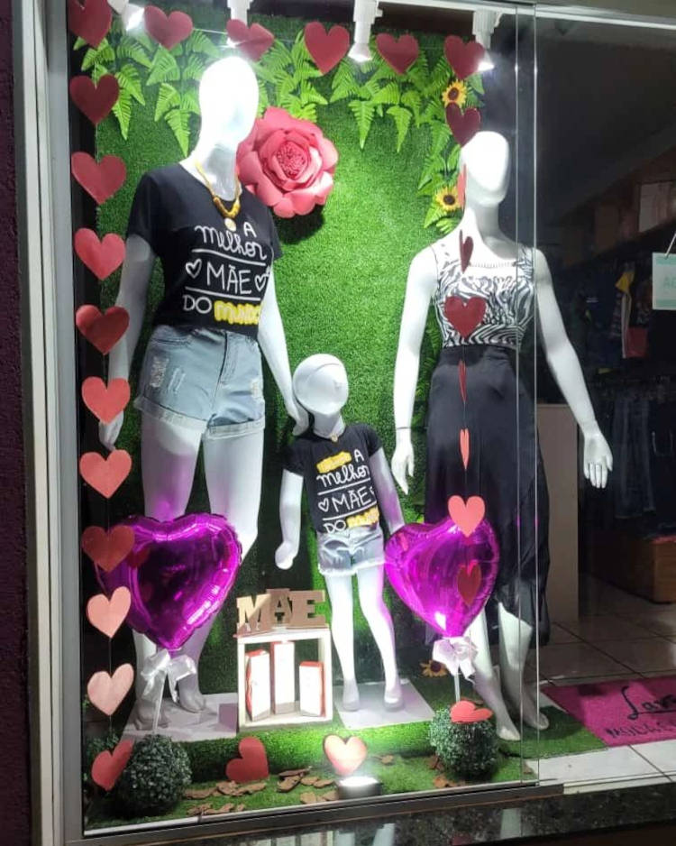 Roupa adulta e infantil com vitrine decorada.