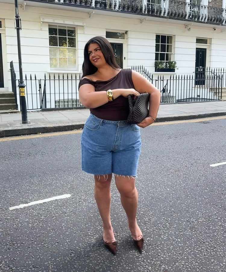 Foto de mulher morena usando regata assimétrica marrom com bermuda jeans, um dos looks para trabalhar no calor