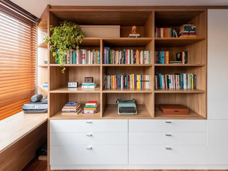 Móvel do home-office, com muitos livros nas repartições, máquina antiga de escrever, impressora, caixas e gavetas