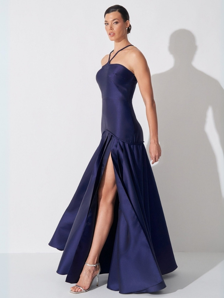 Mulher de pele clara usando vestido azul marinho minimalista com fenda 