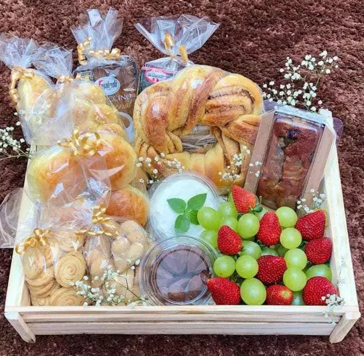 Cesta para café da manhã com frutas, pães e biscoitos 