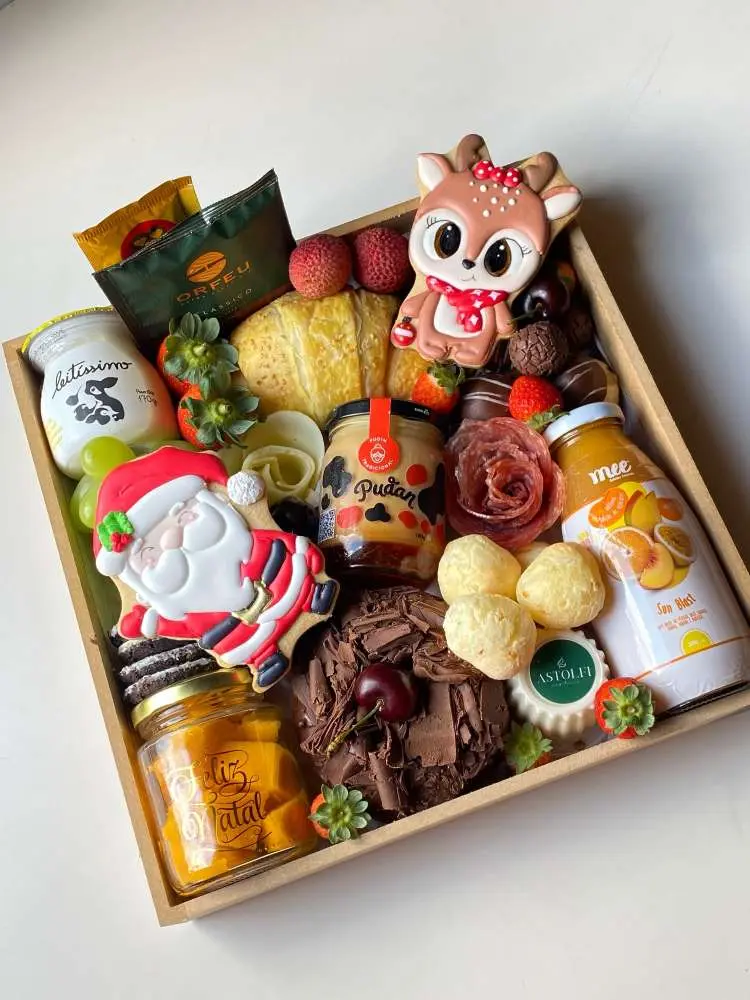 Caixa de Natal com itens de café da manhã, como iogurte, bolo e docinhos. 