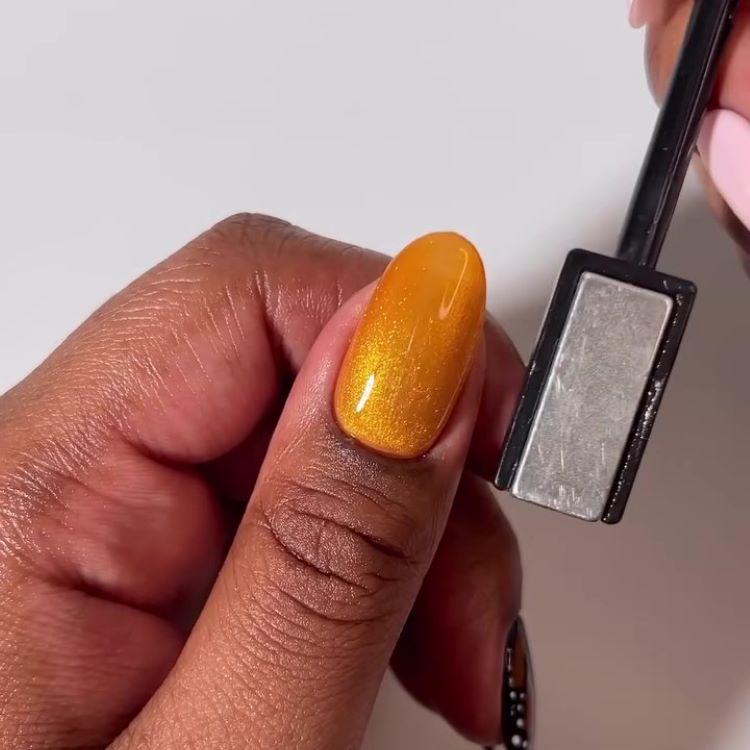 Uso de imã próximo à unha para formar o efeito metalizado no esmalte.
