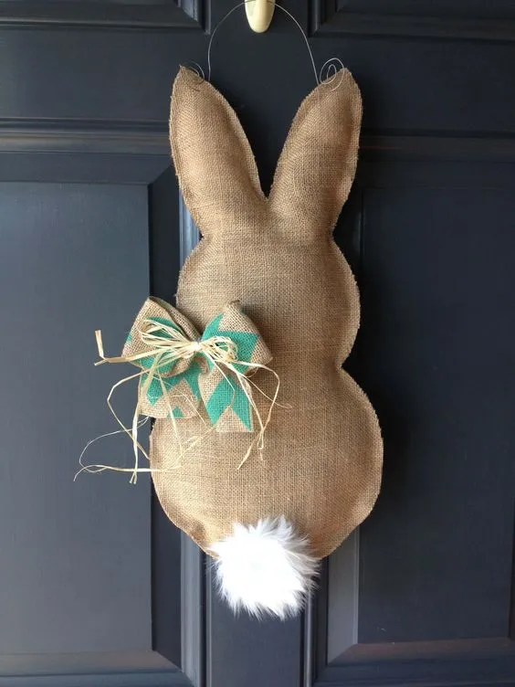 Coelho de jura com laço pendurado em uma porta preta