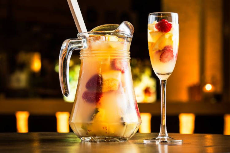 Drink em jarra chamado sangria de frutas amarelas.