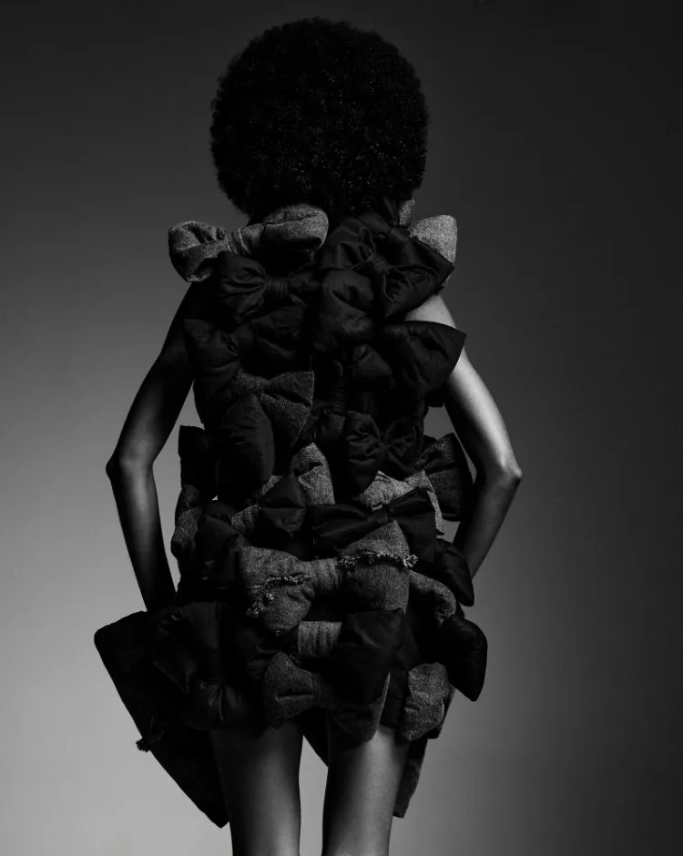 Foto de modelo usando vestido preto com laços no desfile de Sou de Algodão durante o SPFW N60