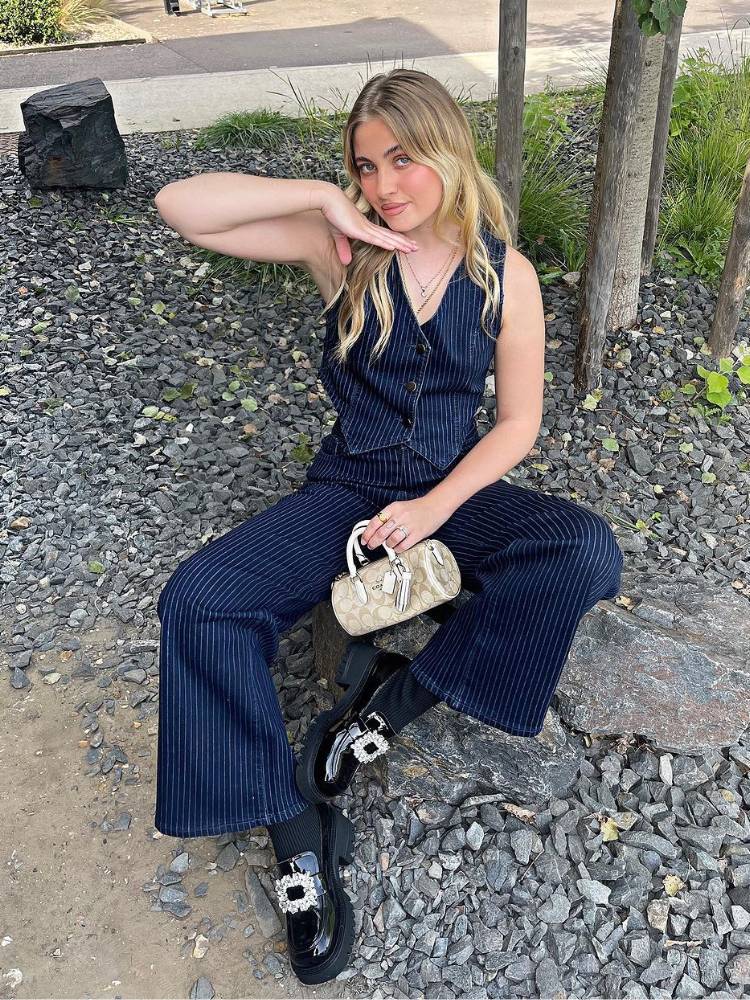 mulher usando colete e calça de risca de giz com mocassim tratorado