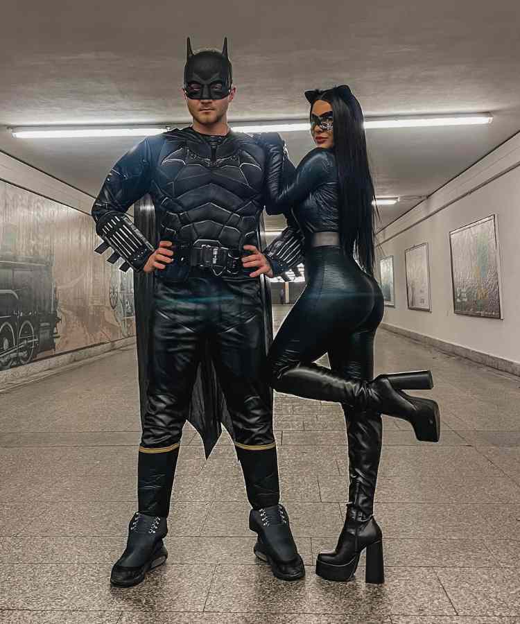 Fantasia de casal para o Halloween: Batman e Mulher-Gato. Ele usa roupa toda preta igual a do Batman, além da máscara do herói. Ela usa macacão preto, orelha de gato e máscara preta 