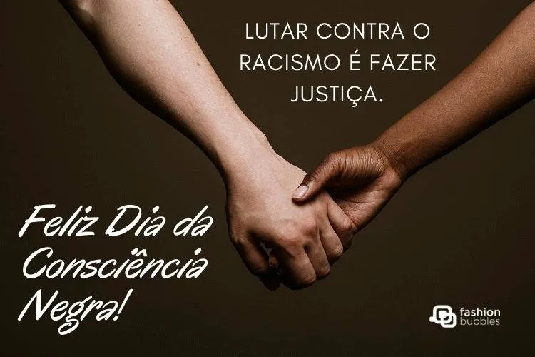 Foto de mãos dadas entre pessoa de pele clara e negra, além de frase "Lutar contra o racismo é fazer justiça. Feliz Dia da Consciência Negra!"