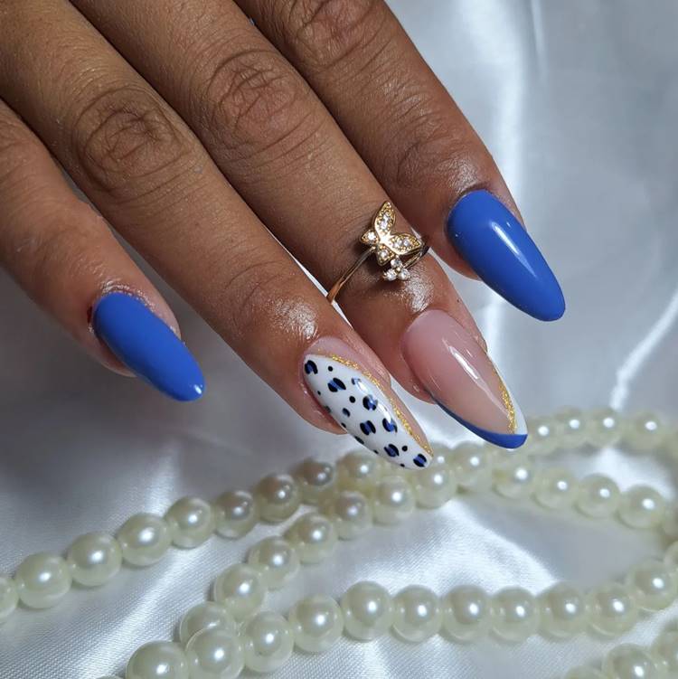 Unha decorada de azul branco preto e dourado. Filha única possui oncinhas de Tom azul em fundo branco