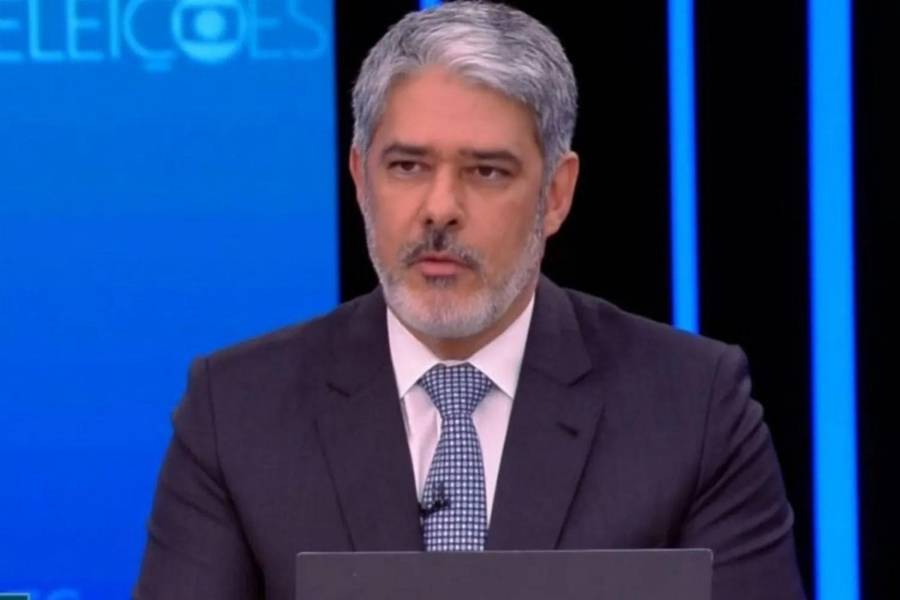 Foto de William Bonner na bancada do Jornal Nacional. 