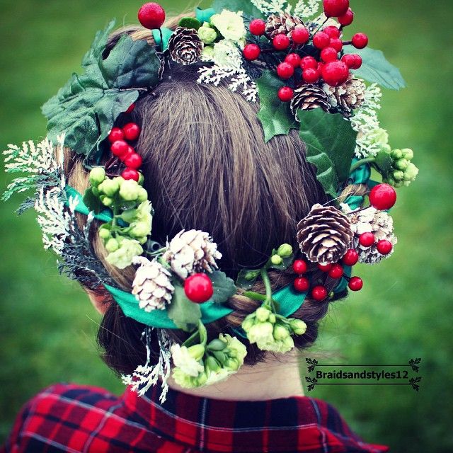 Mulher de cabelo castanho com coroa de flores natalinas, pinhão e mais