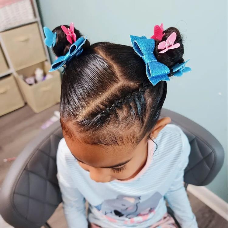 Criança de pele morena com space buns, trança e acessórios 
