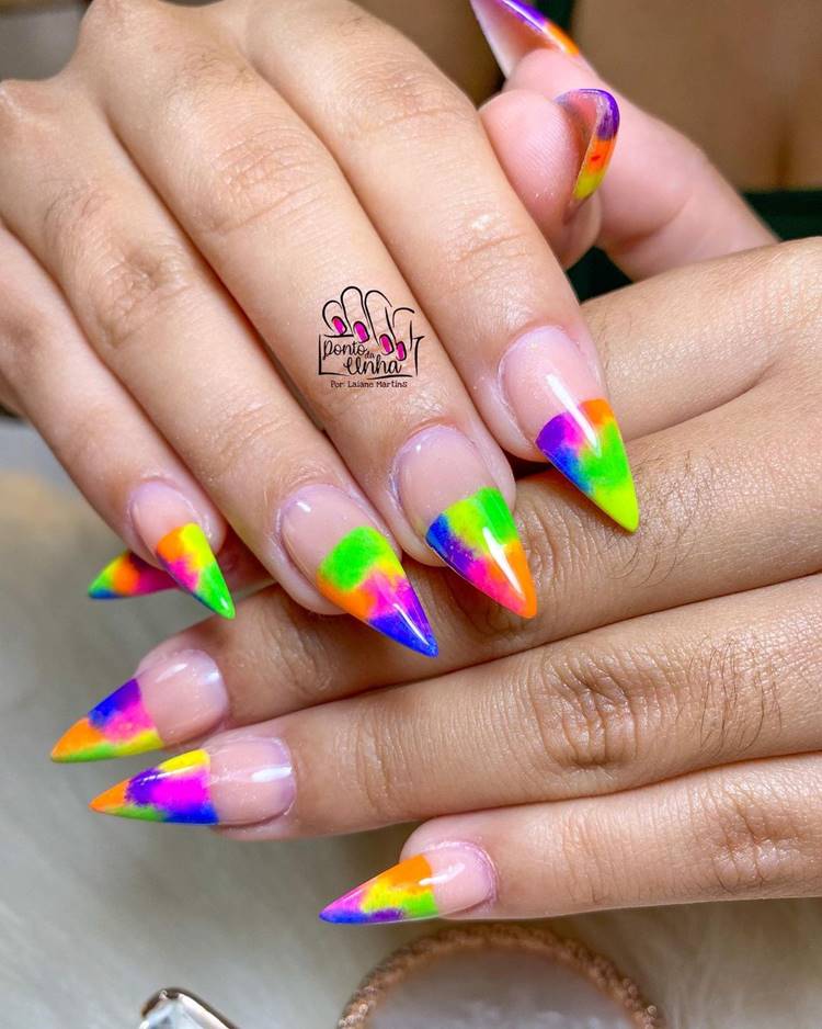 Mão com unhas decoradas coloridas: Polegar: nude com a ponta colorida neon Indicador: nude com a ponta colorida neon Médio: nude com a ponta colorida neon Anelar: nude com a ponta colorida neon Mínimo nude com a ponta colorida neon