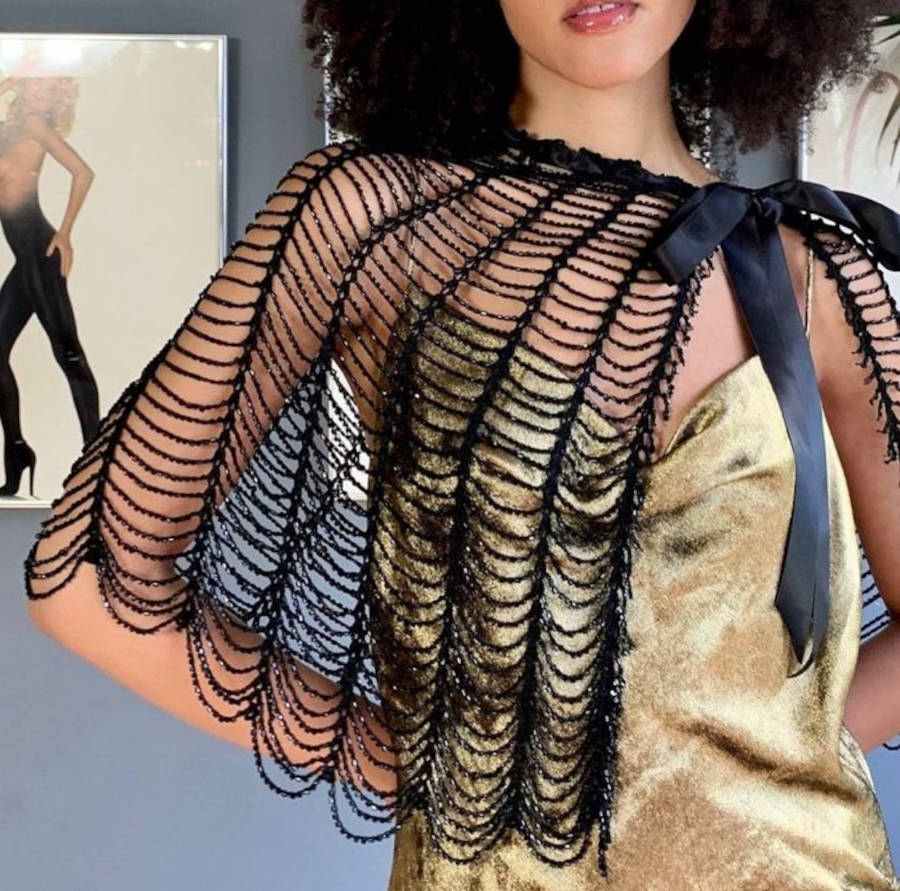 Imagem do tronco de uma mulher com uma capa de Teia de Aranha feita de crochê