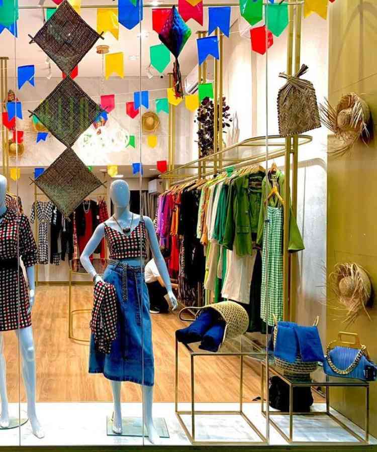 Vitrine decorada com bandeirinhas + acessórios de palha, como cestas, chapéus, bolsas