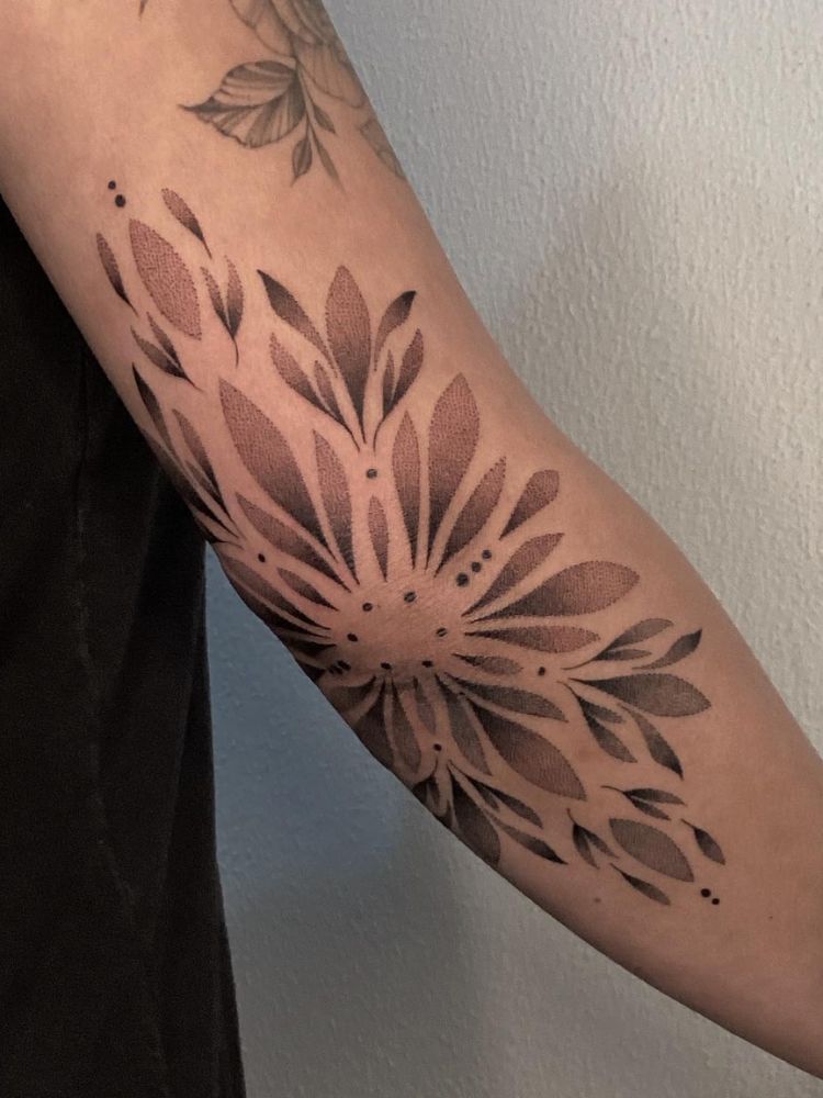 Tatuagem de folhas em pontilhismo no cotovelo 
