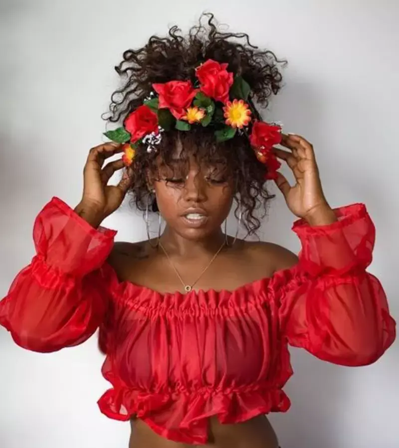 Penteado para cabelo cacheado com arco de flor