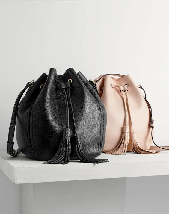 dia das maes presentes: duas bolsas, uma preta e outra bege, sobreposta a superfície